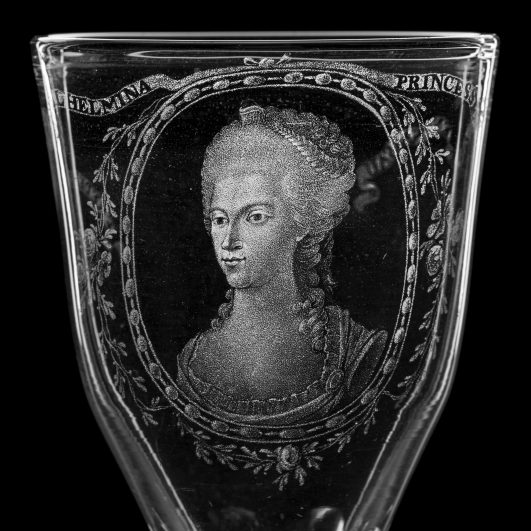 Kristallglas mit graviertem Porträt einer Frau in historischem Stil.