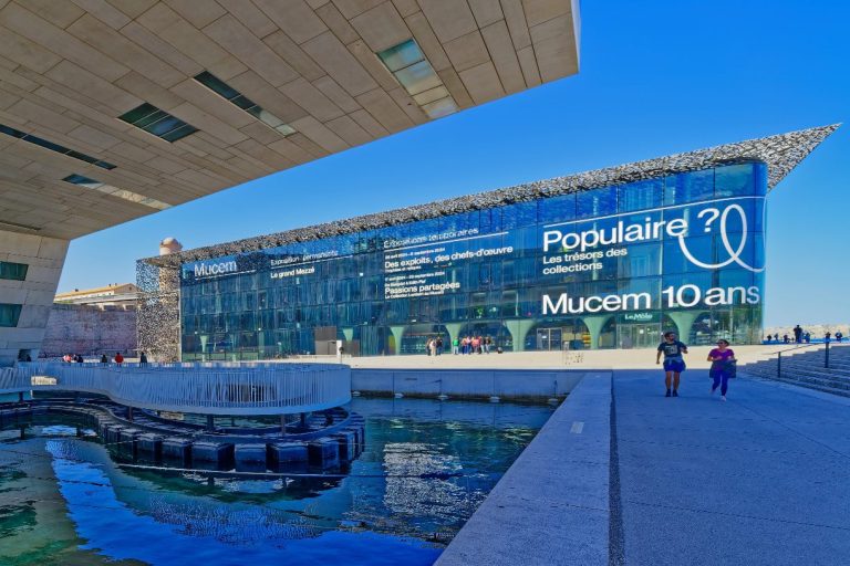 Das Museum MuCEM Moderne Architektur des Museums mit Glasfassade und Wasserfläche im Vordergrund.