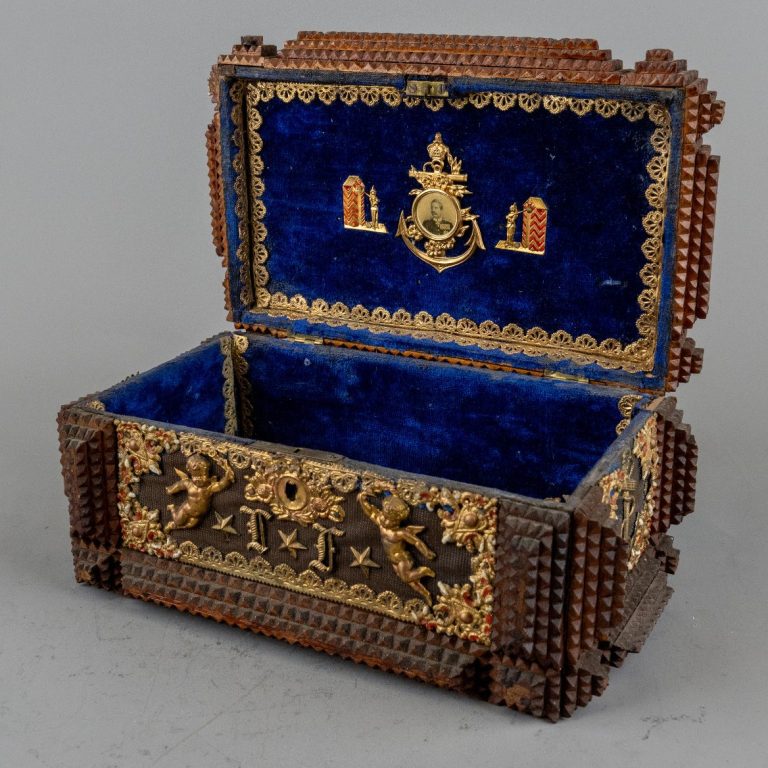 Schmuckkästchen mit blauer Innenauskleidung und goldenen Verzierungen.